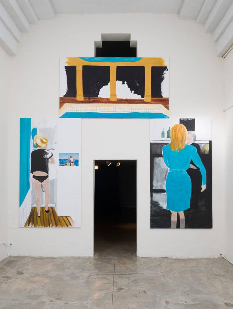 Wand mit Bildern und Durchgang in der Mitte.