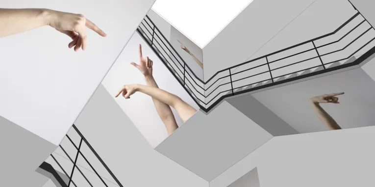 Treppenhaus, in dem Fotografien von zeigenden Armen und Fingern angebracht sind