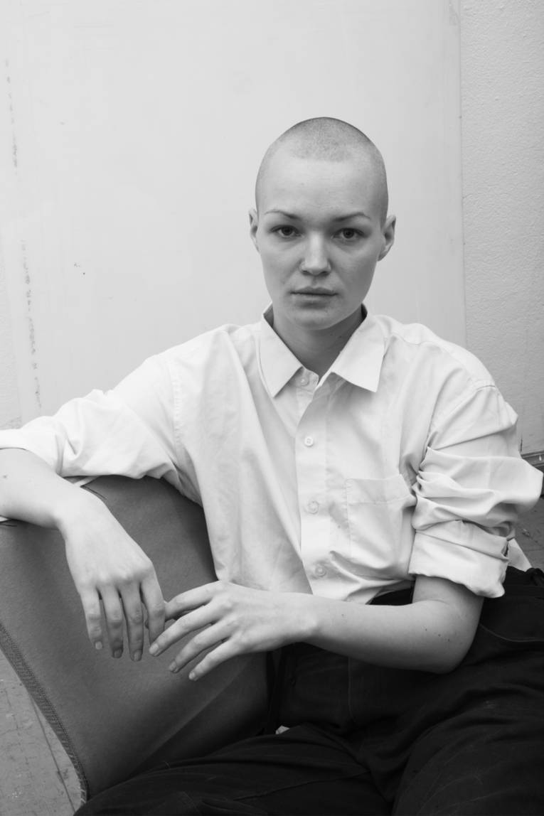 Junge Frau mit geschorenem Schädel.