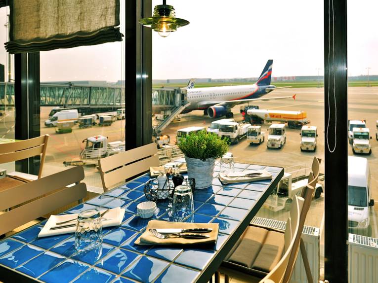 Blick aus einem Restaurantfenster auf ein Flugzeug
