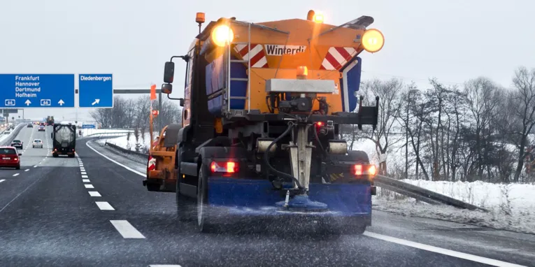 Ein Streufahrzeug auf einer Straße.