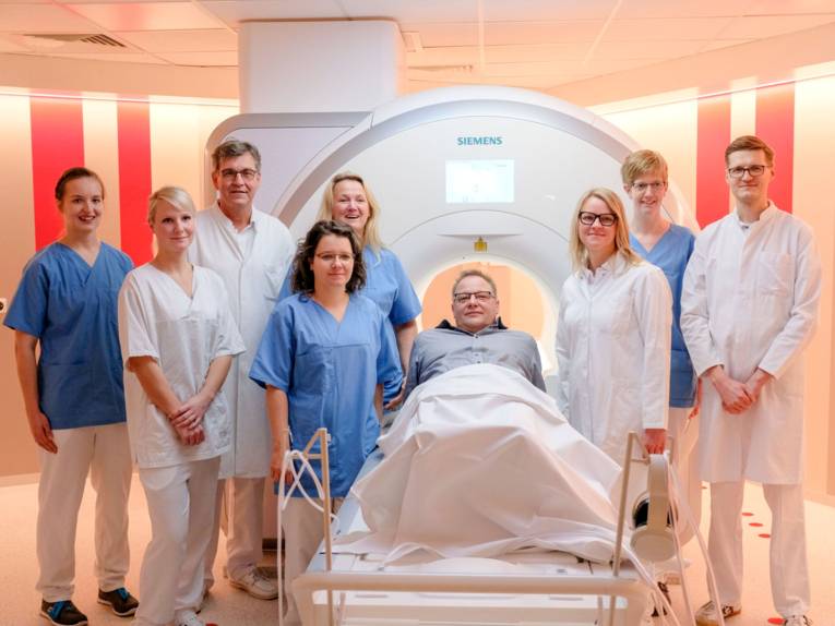 Medizinisches Personal mit liegendem Patienten vor MRT
