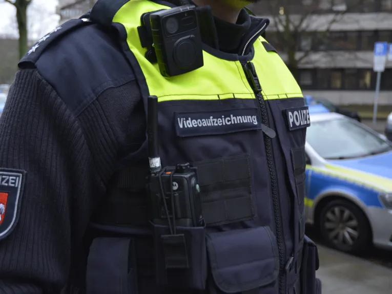 Nahaufnahme eines Polizeibeamten, der eine kleine Kamera am Körper trägt