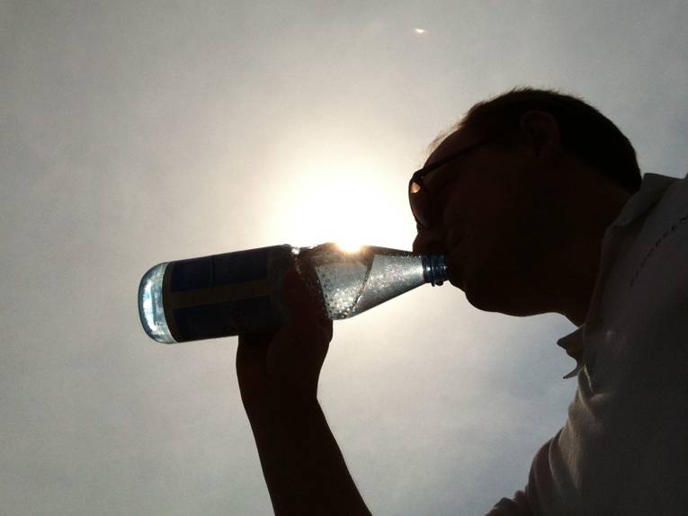 Ein Mann trinkt aus einer Flasche 