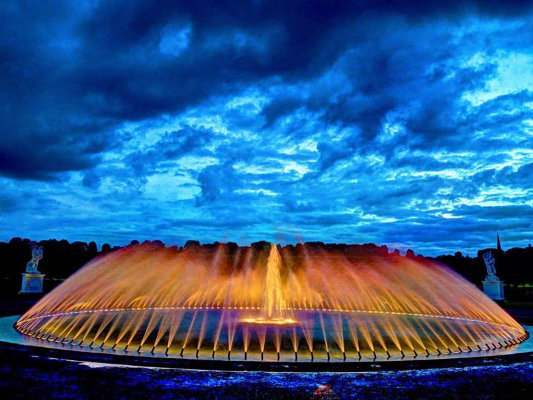 Angestrahlter Brunnen in der Dämmerung