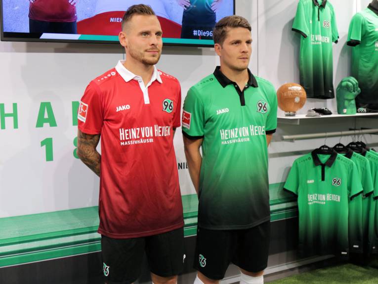 Zwei Fußballspieler von Hannover 96 in rotem und grünem Trikot