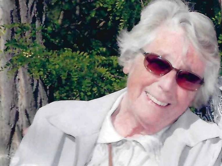 Lächelnde Frau mit weißem Haar und Sonnenbrille