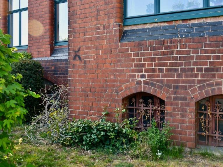 Hausmauer mit schwarzem Kreuz