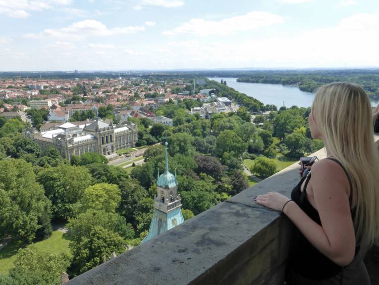 Eine Frau schaut sich die Landschaft von oben an.