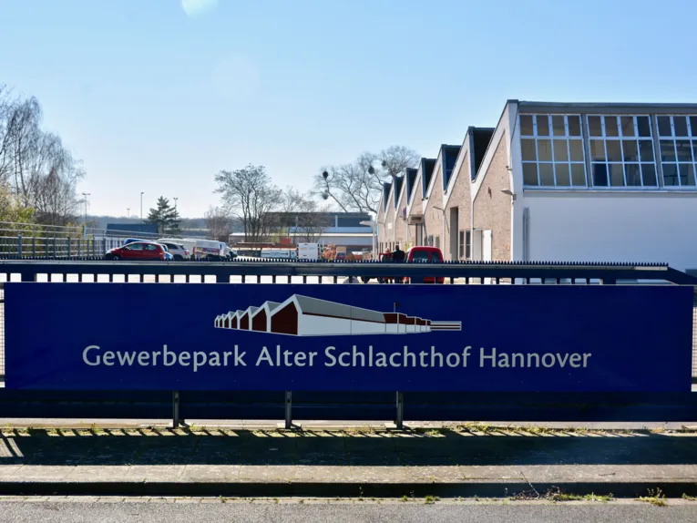 Gebäude-Ensemble, davor ein Schild mit der Aufschrift "Gewerbepark Alter Schlachthof"