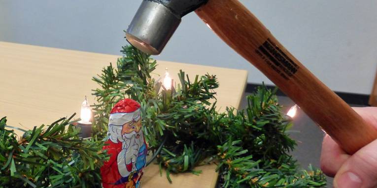 Hammer schlägt auf Schokoladen-Weihnachtsmann