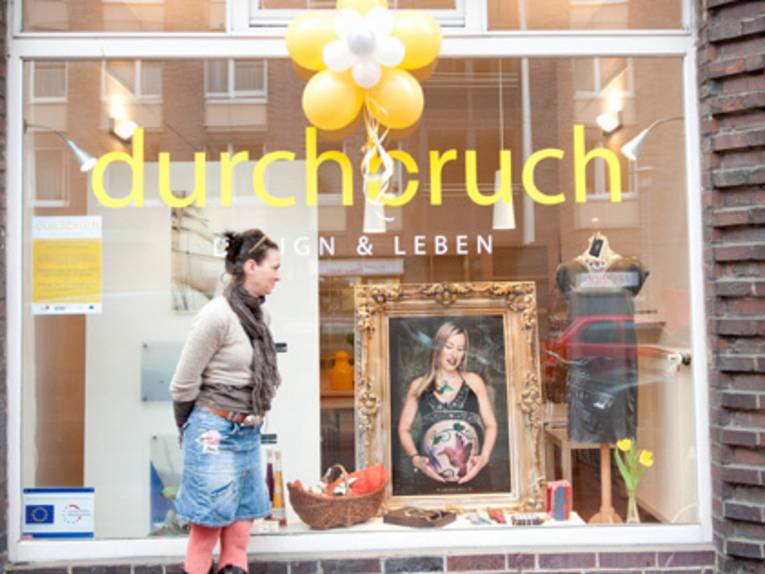 Eine Frau steht vor einem Laden.