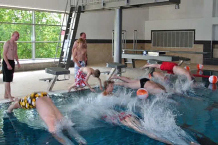 Schwimmer springen mit einem Kopfsprung vom Beckenrand