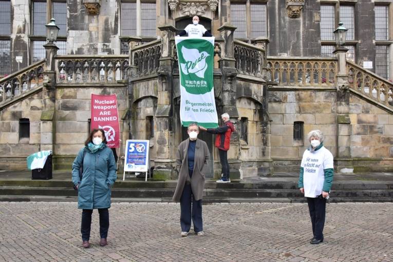 Menschen mit Mayors for Peace-Flaggen 