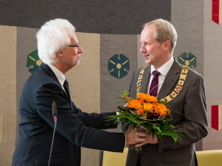 Bernd Strauch überreicht Stefan Schostok einen Blumenstrauß