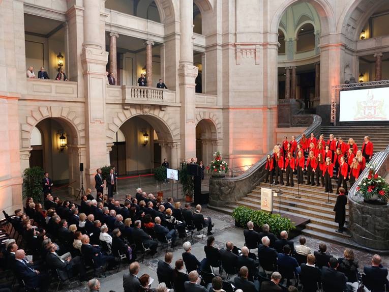 Sängerinnen des Mädchenchors Hannover auf der Treppe in der Rathaushalle, davor die sitzenden Gäste Gerhard Schröders