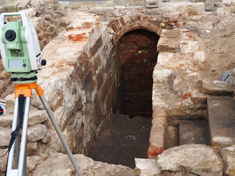 Vermessungsgerät vor Ausgrabungsstätte