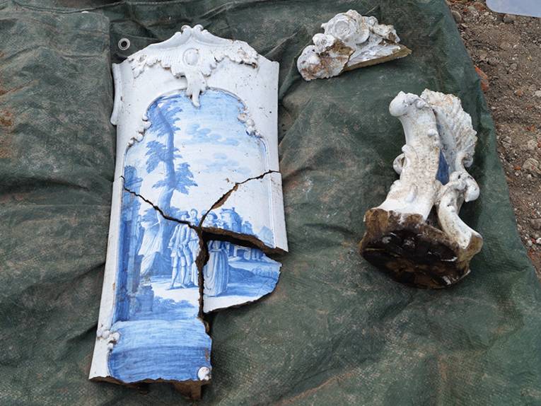 Beschädigte Teile eines verzierten Kachelofens