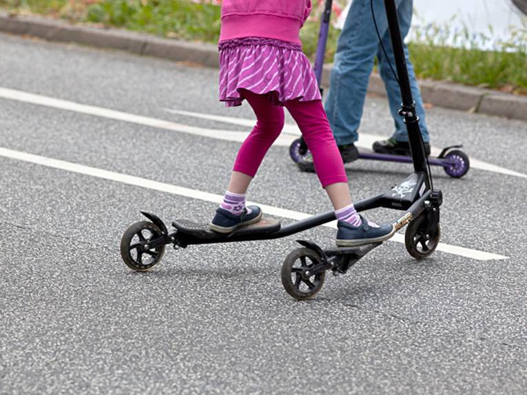 Kinder probieren verschiedenartige Roller aus