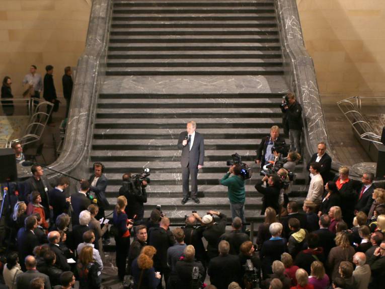Stefan Schostok während seiner Ansprache auf der Treppe in der Rathaushalle, vor ihm mehr als ein Dutzend Medienvertreter