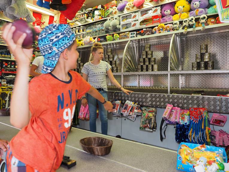 Junge wirft auf Dosen in einer Bude. 