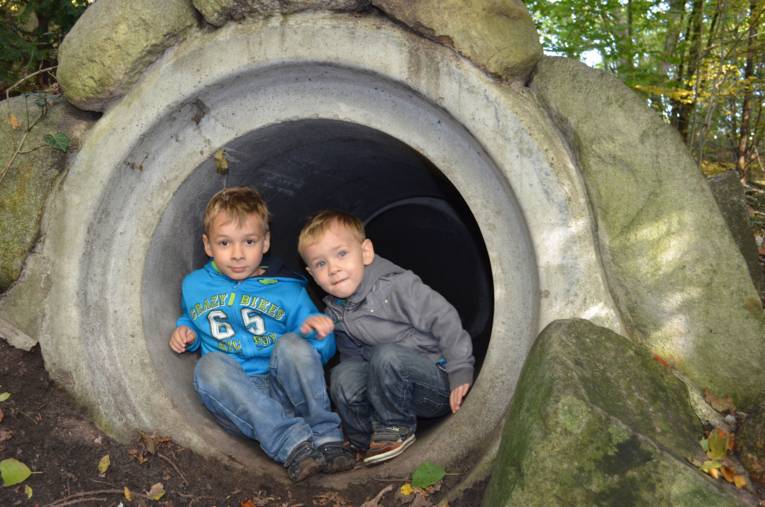 Zwei kleine Jungen erkunden eine Betonröhre