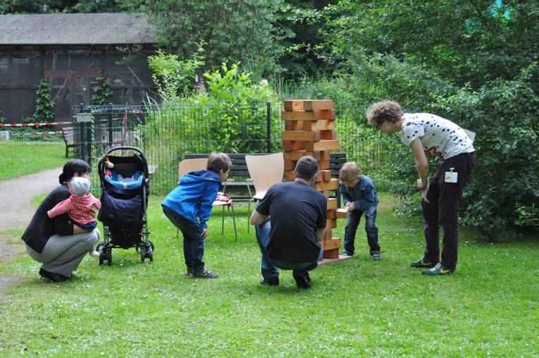 Kinder und Erwachsene beim Jenga-Spiel