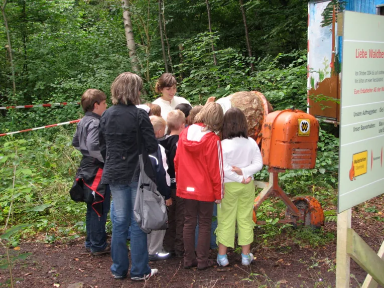 Kinder und Betreuerinnen vor Betonmischer stehend