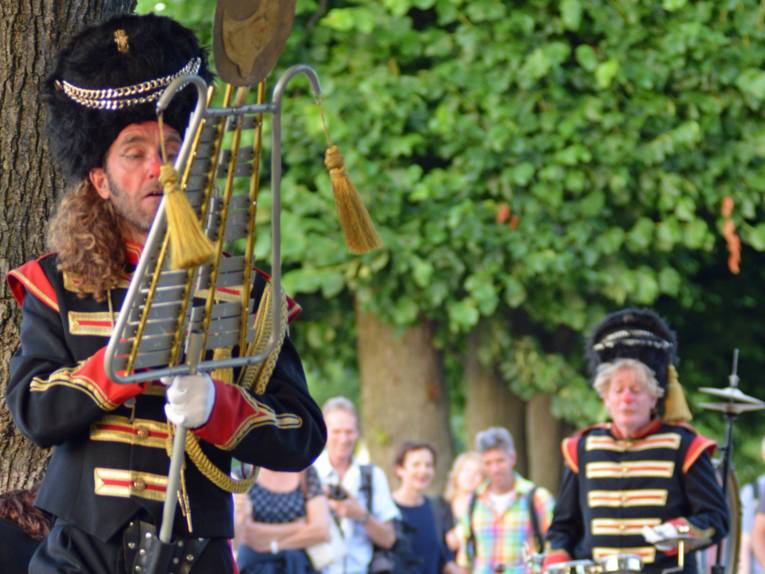 Menschen und Künstler bei einem Fest unter freiem Himmel. 