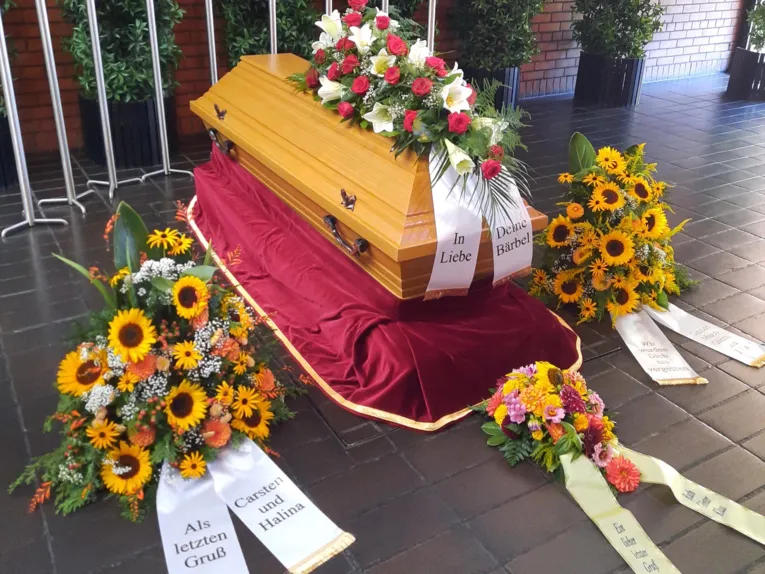 Blumen auf und um einen Sarg.