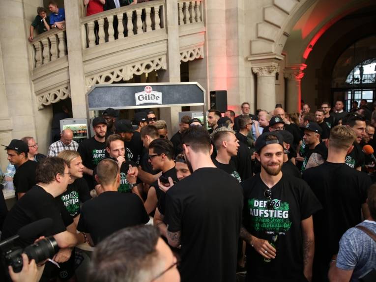 Menschen vor und in einem Rathaus. 