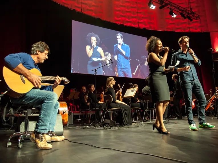 Musikerinnen und Musiker musizieren auf einer Bühne.