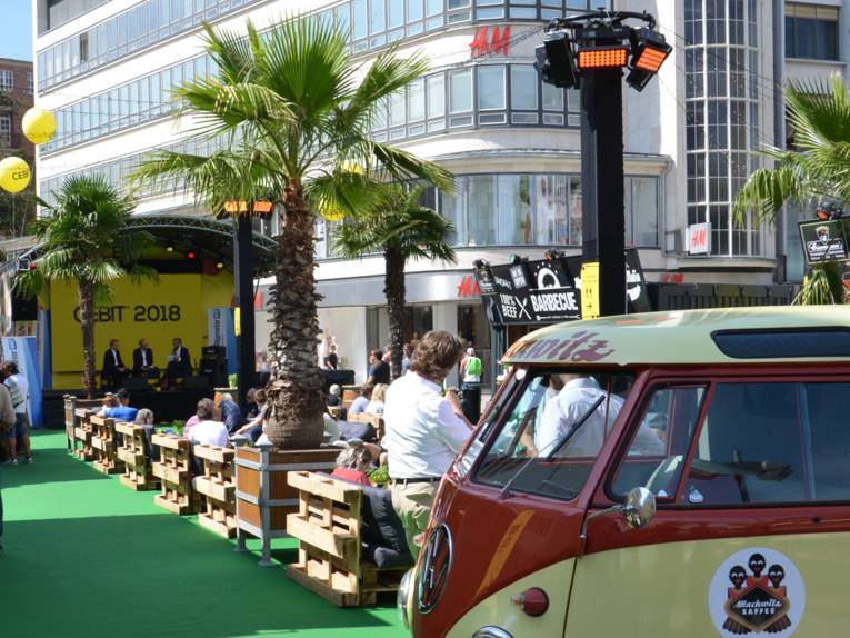 VW-Bus und kleine Bühne auf einem öffentlichen Platz