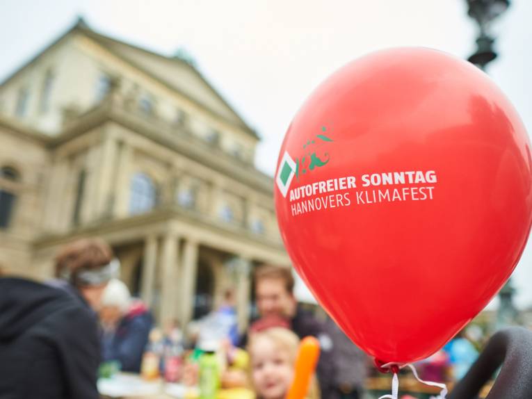 Roter Luftballon mit der Aufschrift "Autofreier Sonntag" vor der Oper