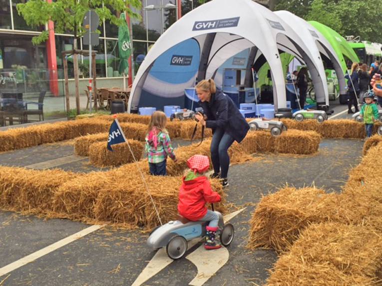 Kleines Kind mit einem Kinderfahrrad zwischen Strohballen
