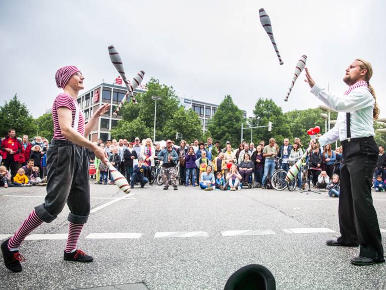 Zwei Jongleure wirbeln am Aegi mehrere Keulen durch die Luft