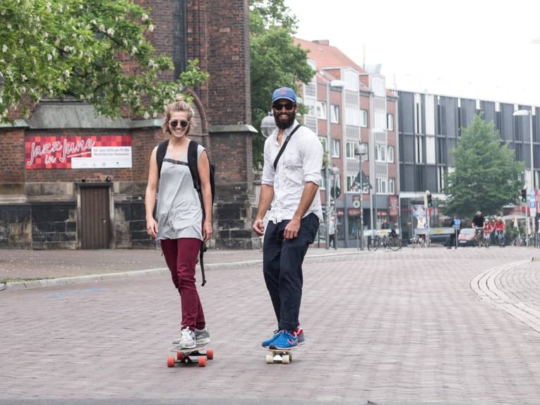 Eine Skaterin und ein Skater nutzen die für Autos gesperrte Schmiedestraße