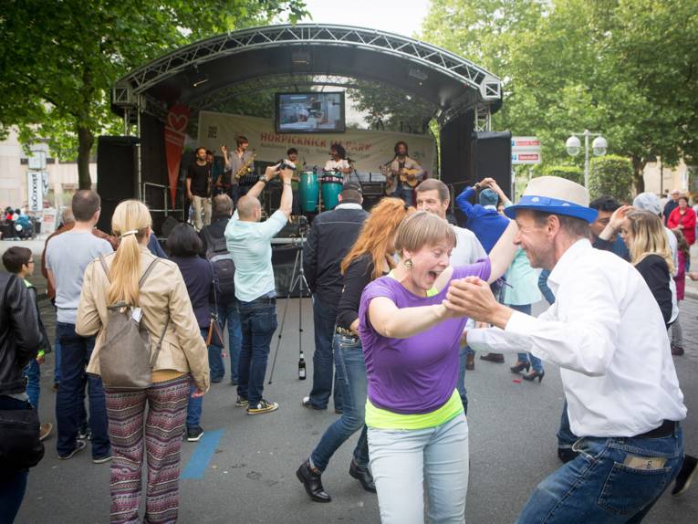 Vor einer Musikbühne tanzen Leute