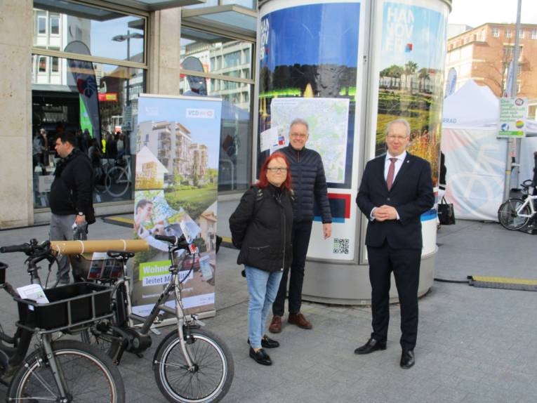 Oberbürgermeister Stefan Schostok steht mit zwei interessierten Bürgern neben zwei Pedelecs am Kröpcke.