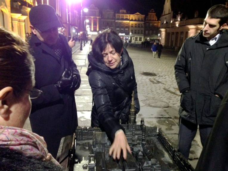 Eine Frau gibt anhand eines Modells Infos zur Altstadt Poznan.