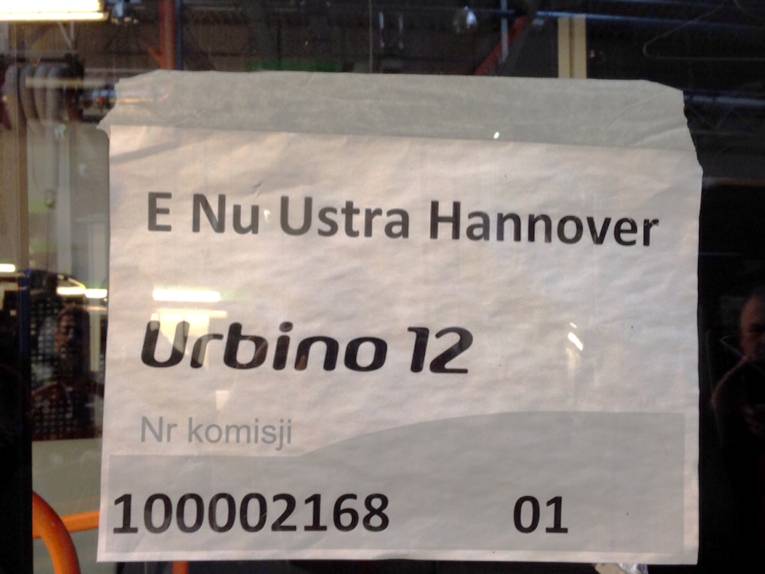 Ein Weißer Zettel mit der Aufschrift "E Nu Ustra Hannover" hinter einer Fahrzeugscheibe.