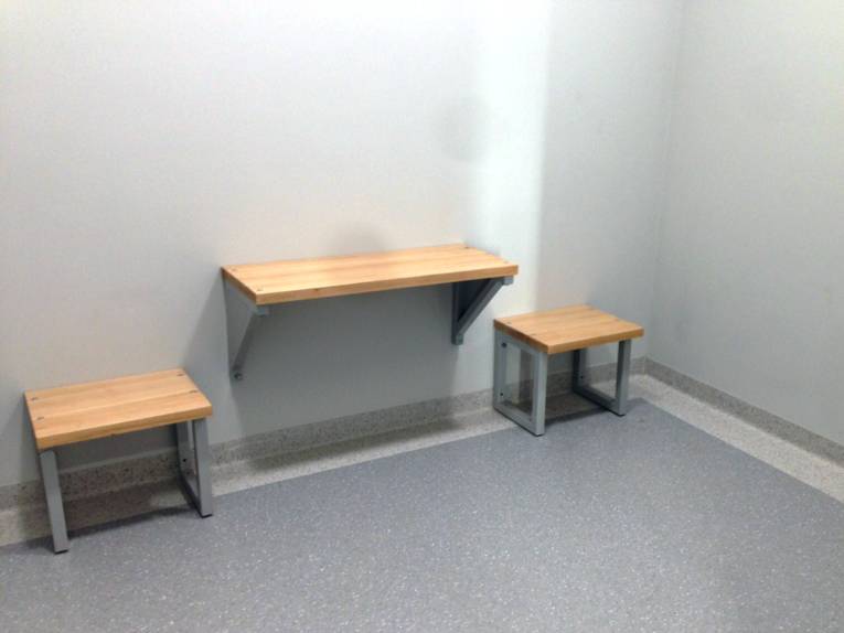 Zwei Hocker und ein Tisch in einer Zelle für Straftäter.