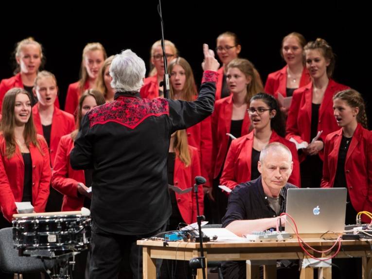 Während des Konzerts "Salto Vocale": David Moss dirigiert den Mädchenchor Hannover, Sam Auinger am PC.