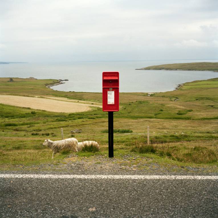 Roter, britischer Briefkasten in freier Natur.