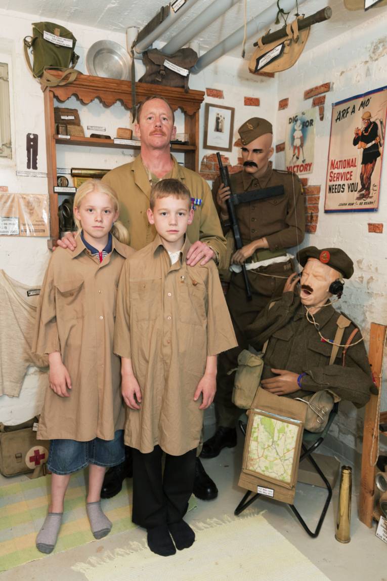 Mann mit zwei Kindern in einem Ausstellungsraum.