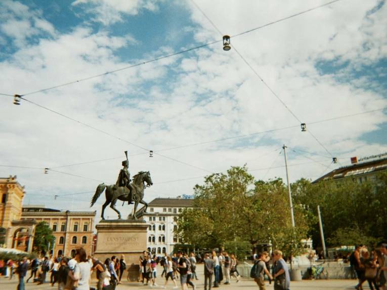 Fotografie, die einen Platz voller Menschen zeigt. 