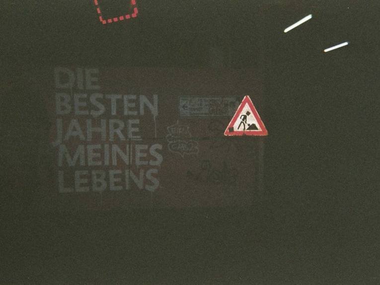 Fotografie, die eine Wand im Dunkeln zeigt. Darauf steht "Die besten Jahre meines Lebens".  