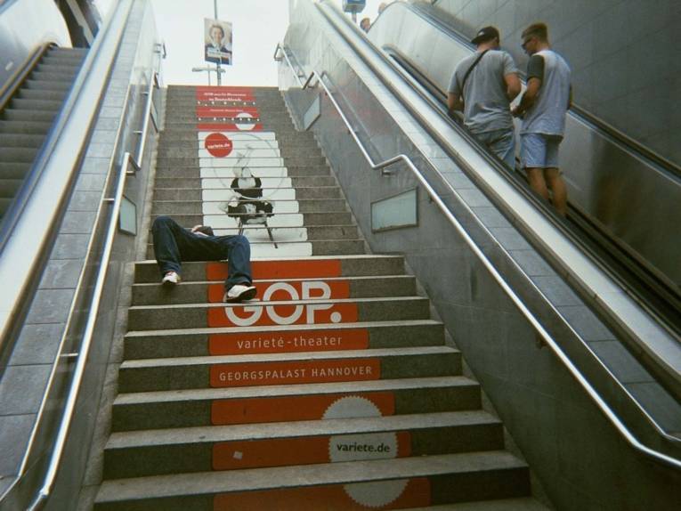 Fotografie. die einen Mann zeigt, der auf Treppenstufen liegt. 