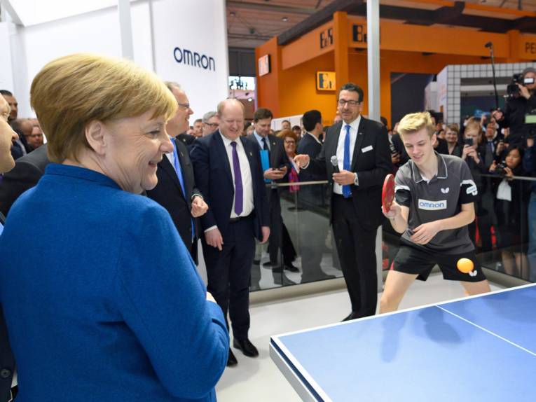 Verschiedene Personen an einem Messestand