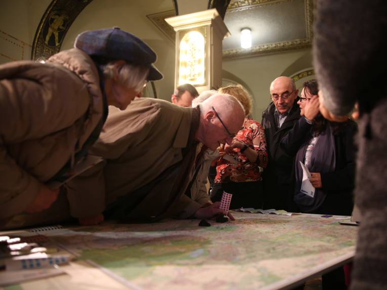 Ein älterer Herr beugt sich über eine Stadtkarte.